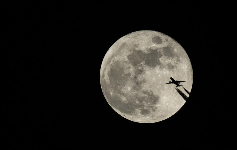 A plane crossing the full moon